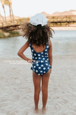 PINK DESERT GIRLS MINI RUFFLE LEG SCOOP ONE PIECE SWIMSUIT IN SPANGLED STAR PRINT